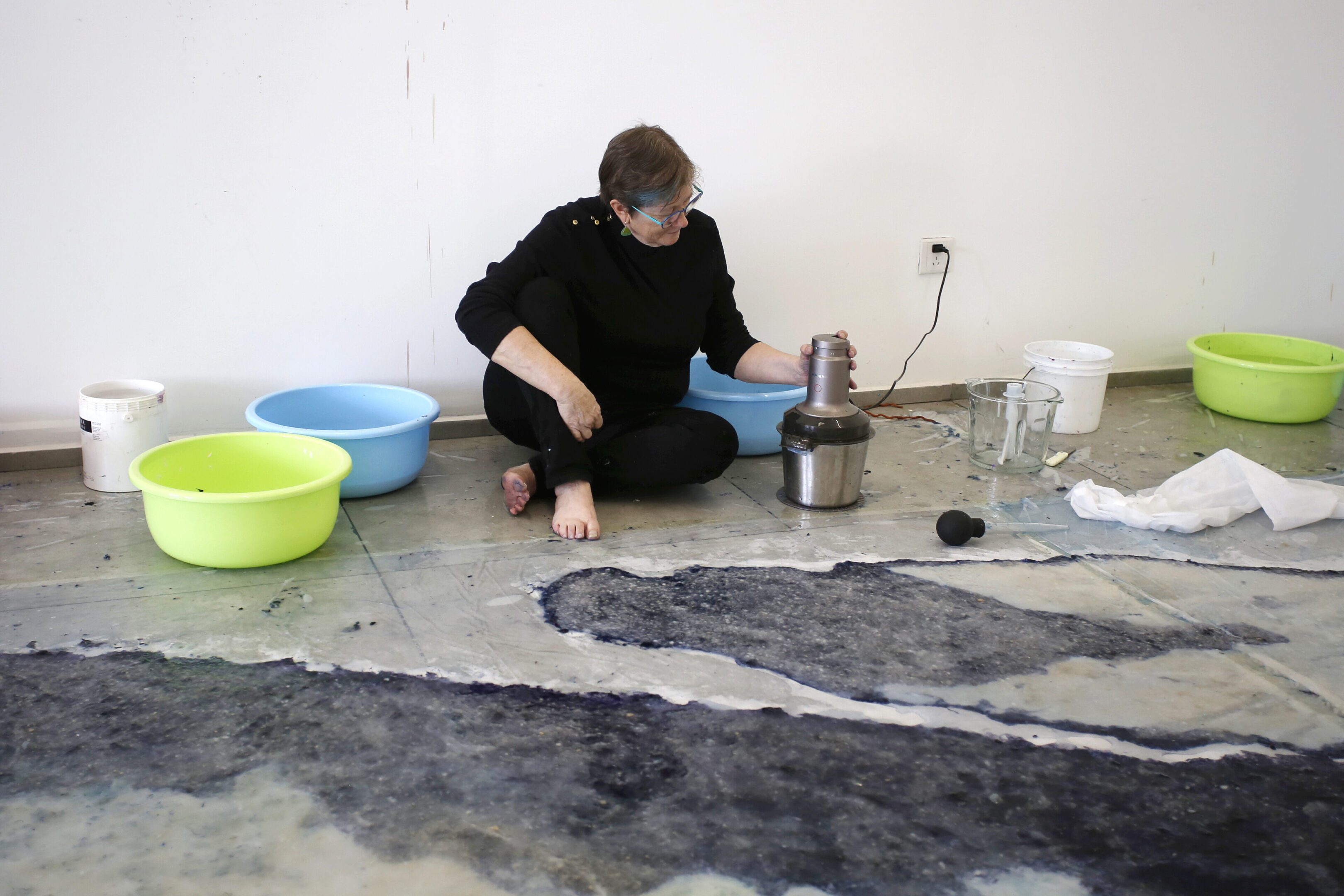 Artist with bowls and juicer on floor