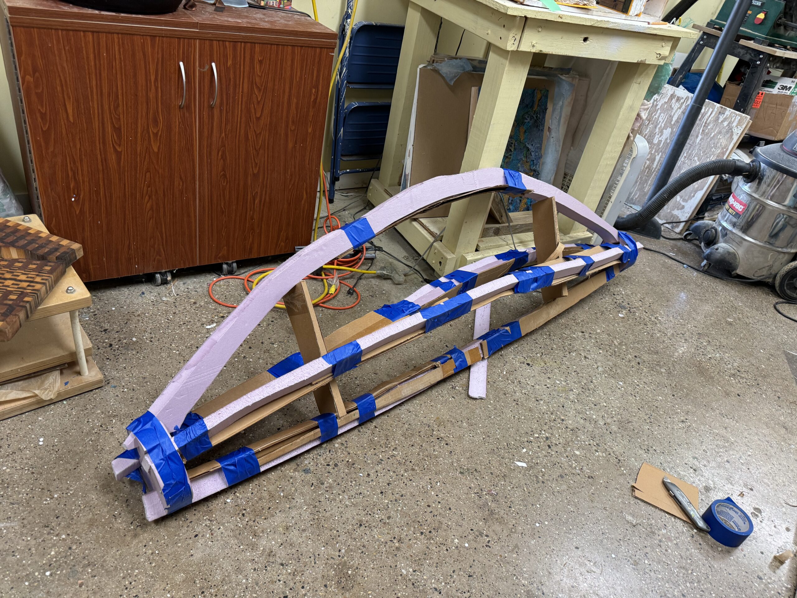 Wood and foam structure on workshop floor.