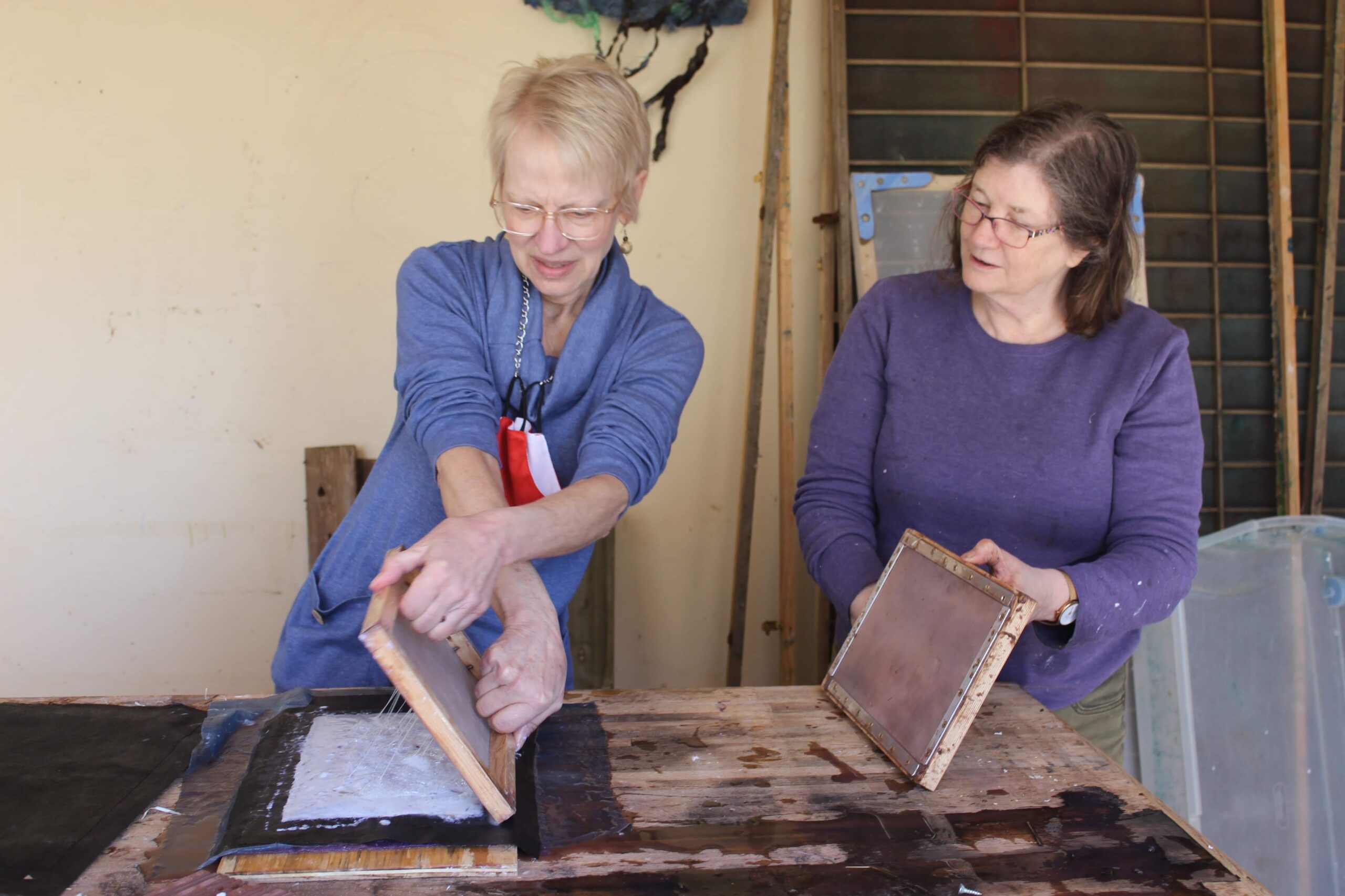 Two women making handmade paper together